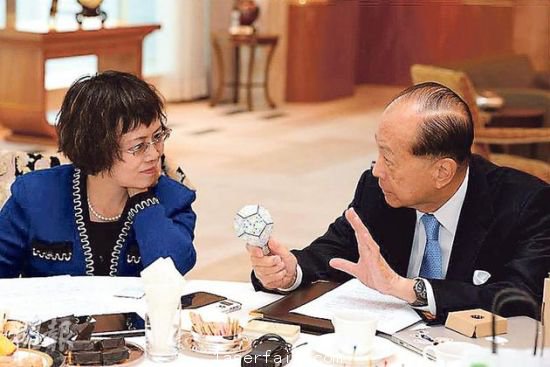 李嘉誠（右）在接受媒體訪問時指出，長實集團以香港為基地，常常積極在港尋找投資機會，但是政府很多政策，需時消化。圖為他向財新傳媒總編輯胡舒立介紹他本周的“最愛”納米LED燈泡。圖片來源：香港明報